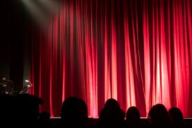 Red stage curtains with spotlight falling on them.