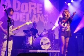 Adore Delano on stage at The 1865, smiling and pointing to audience.